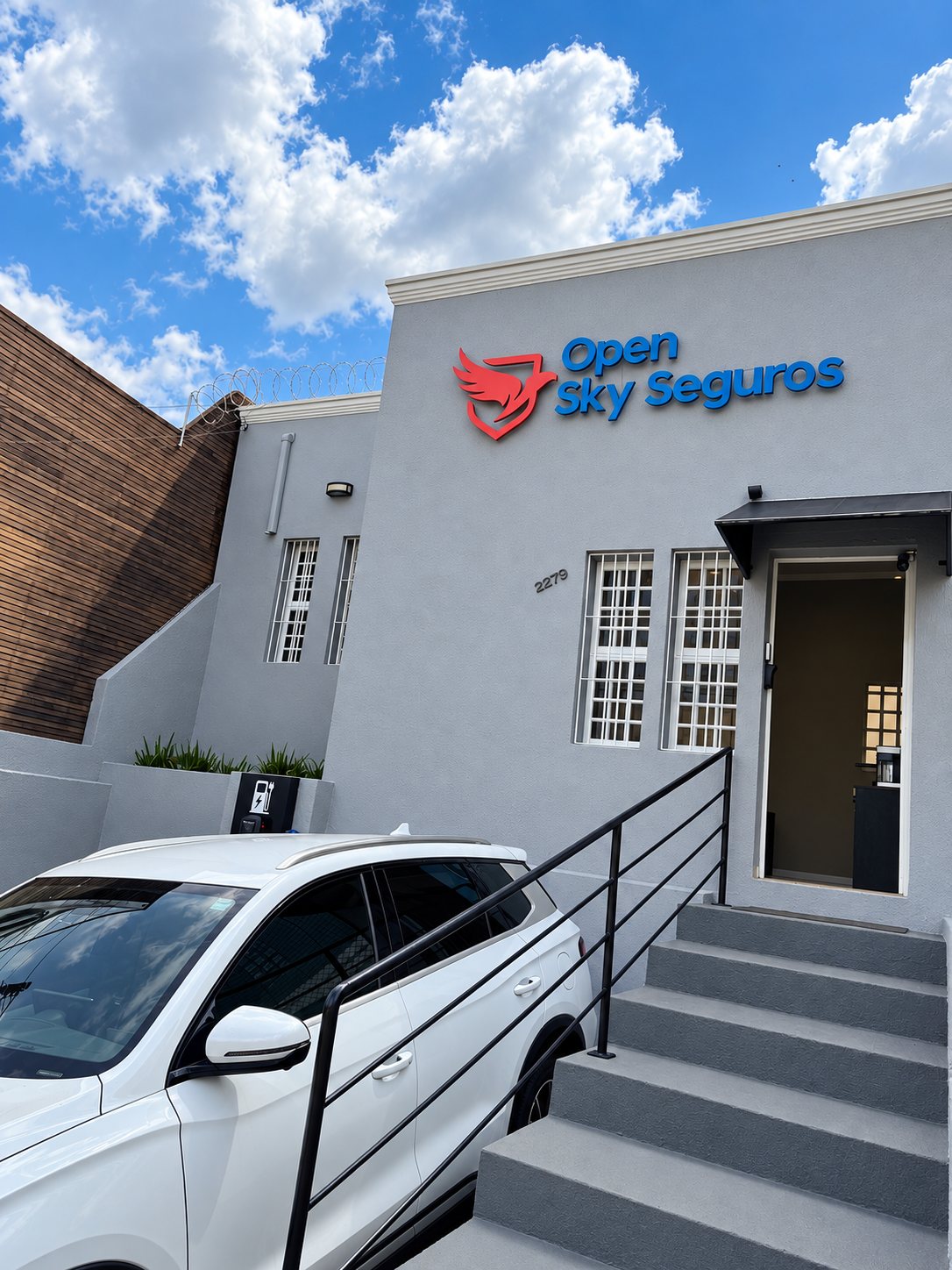 Fachada da Open Sky Seguros vista de lado, com a escada da entrada
